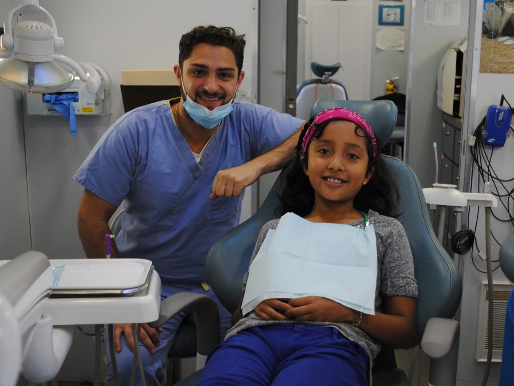 A dentist and child smiling after a dental visit. 