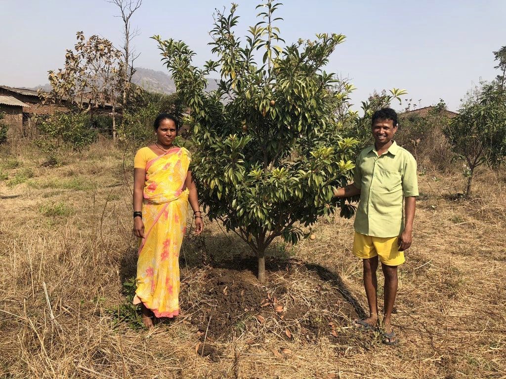 Sudhakar and his wife Sangita proudly posing by one of their fruit trees in 2018